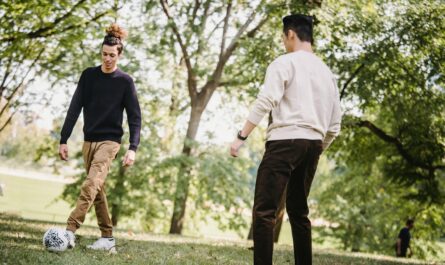 https://www.pexels.com/photo/positive-ethnic-male-friends-playing-football-in-park-5553089/