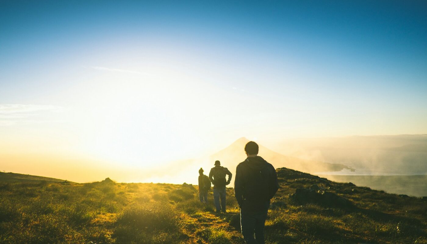 silhouette of three men falling in line while walking during golden hour