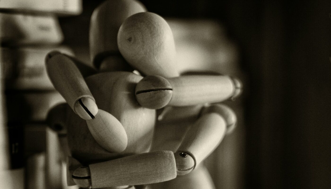 two wooden dummy hugging figures