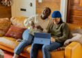 a person sitting on a couch with a laptop