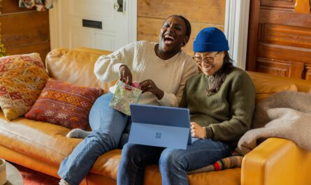 a person sitting on a couch with a laptop